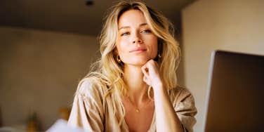 Focused woman pausing mid-work with quiet confidence, illustrating the dependable qualities people raised with a strong work ethic carry through life.