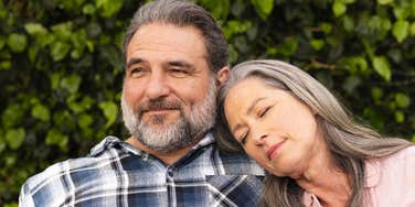 woman resting head on man's shoulder