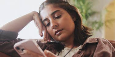 Person scrolls social media and feels sick.