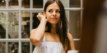 Woman sitting with friends while feeling detached and uncomfortable showing the signs you’ve outgrown your social circle and are ready to move up in life.