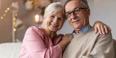 upper middle class older couple sitting comfortably in their home