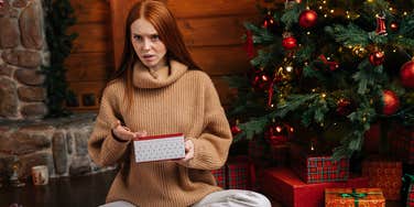 gen z woman opening bad christmas gift