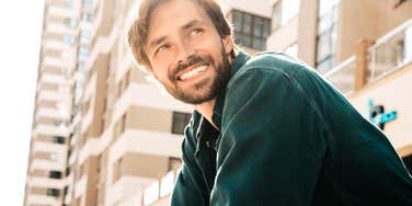 Man smiling softly with genuine warmth showing the sweet ways real men describe what it feels like to fall in love.