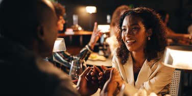 woman out to dinner and holding hands with partner at restaurant