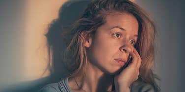 unhappy upset woman sitting at home alone