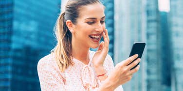 Wife laughing at a text from her husband that she loves 