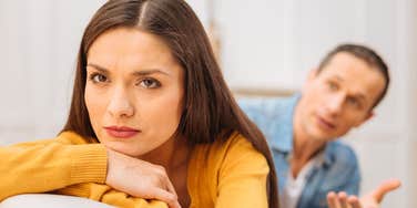 passive-aggressive woman ignoring husband trying to talk to her