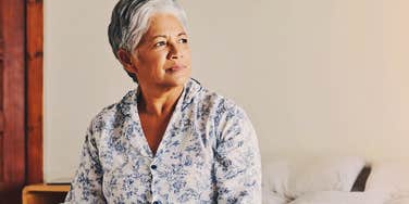 older woman waking up before 6am sitting in bed