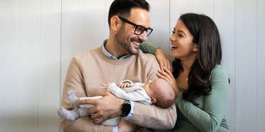 happy couple holding baby