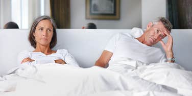 upset couple sitting in bed together