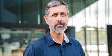 serious man standing in front of office building
