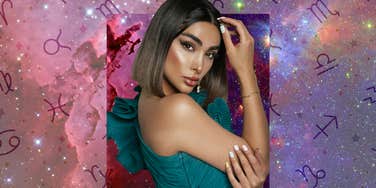 Woman posing against cosmic background with zodiac symbols, representing four zodiac signs rewarded by the universe on December 4, 2025