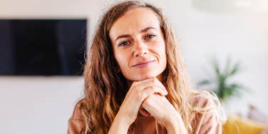 A woman sitting calmly with a thoughtful expression, conveying self-respect, confidence, and emotional maturity.