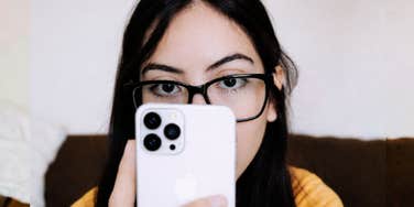 Person using a smartphone while sitting indoors.