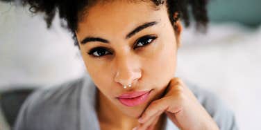 Thoughtful woman with a guarded expression, appearing emotionally weighed down in a quiet moment