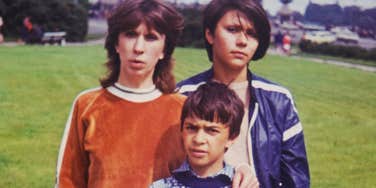 Vintage photo of children standing together in a grassy park.