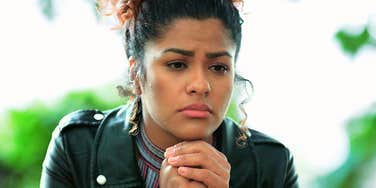 Woman with hands hekd together, feeling down. 