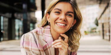 Woman smiling with calm confidence, reflecting the mindset and daily habits behind long-term success
