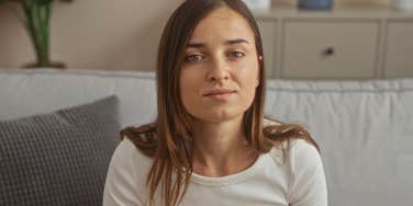 rude woman about to insult someone sitting on couch