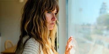sad isolated woman who grew up never fitting in looking out the window