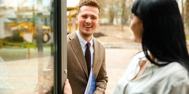 People Who Almost Always Hold The Door For Strangers Usually Have These Specific Personality Traits polite man holding the door for stranger woman