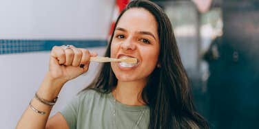 A woman brushing her teeth in a bathroom.