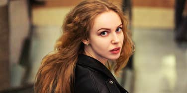 A woman looking back over her shoulder indoors.