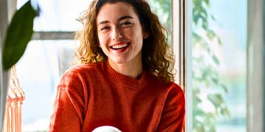 Woman with true integrity smiling near a window 