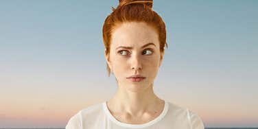 Young redheaded woman is a self-aware genius outcast at the beach