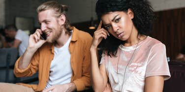 woman annoyed in social situation by rude man on his phone