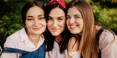 Three close friends sit together outdoors, reflecting the quiet questions that reveal which friendships last and which simply fill space.