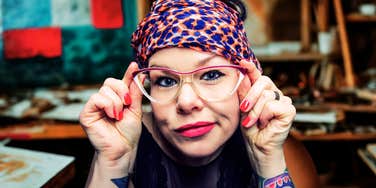 Woman with bold glasses and expressive style looking directly at the camera, reflecting the confidence and inner creativity people often have before they recognize their talent