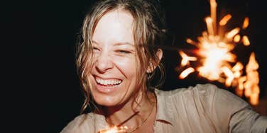 Woman laughing freely in a spontaneous moment of joy, showing how small experiences can make life feel lighter
