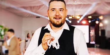 A man in a suit looking over his shoulder during a formal event.