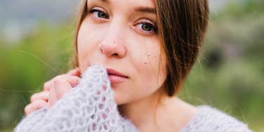 Woman looking calm and reflective outdoors, showing quiet emotional steadiness rather than constant happiness