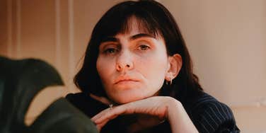 A calm, self-assured woman resting her chin on her hand, reflecting quiet confidence and healthy boundaries in relationships.