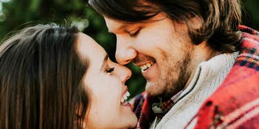 Couple embracing each other closely outside.