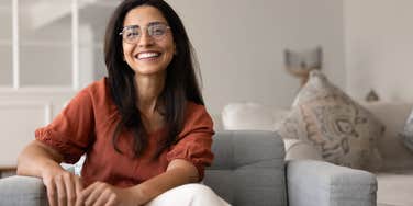 smiling woman sitting on couch at home