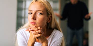 sad woman thinking about leaving her relationship while man yells at her
