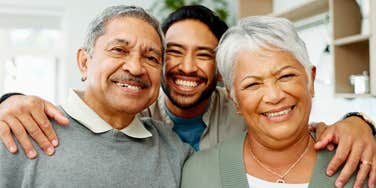 man hugging his parents with whom he has a loving relationship