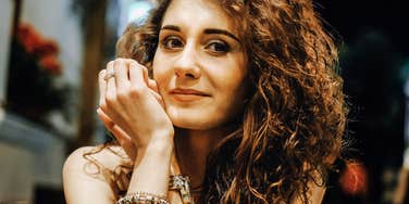 Close-up portrait of a person with curly hair indoors