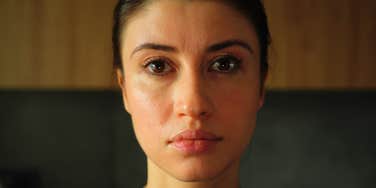 Woman looking directly forward with a distant, unfocused gaze