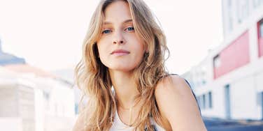 Person looking at the camera outdoors in an urban setting.