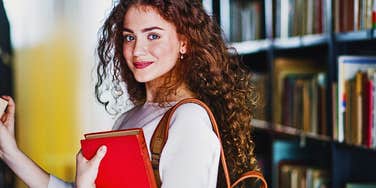 High IQ woman in a library doing things she doesn't realize are special