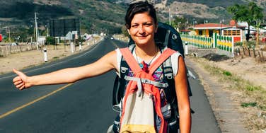 Vintage photo of a woman in the seventies, hitchhiking. 