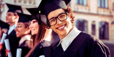 Young man who grew up in a happy home in a graduation gown and cap