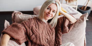 smiling woman relaxing on couch at home