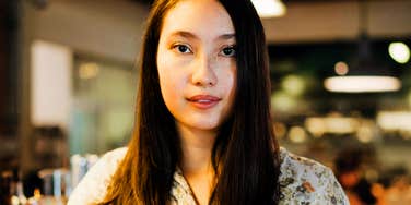 A woman looking at the camera in an indoor public space.