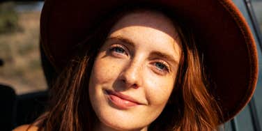 A woman wearing a hat looking at the camera.