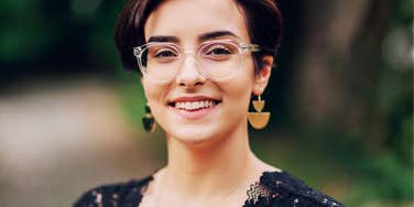 confident woman wearing glasses smiling outdoors